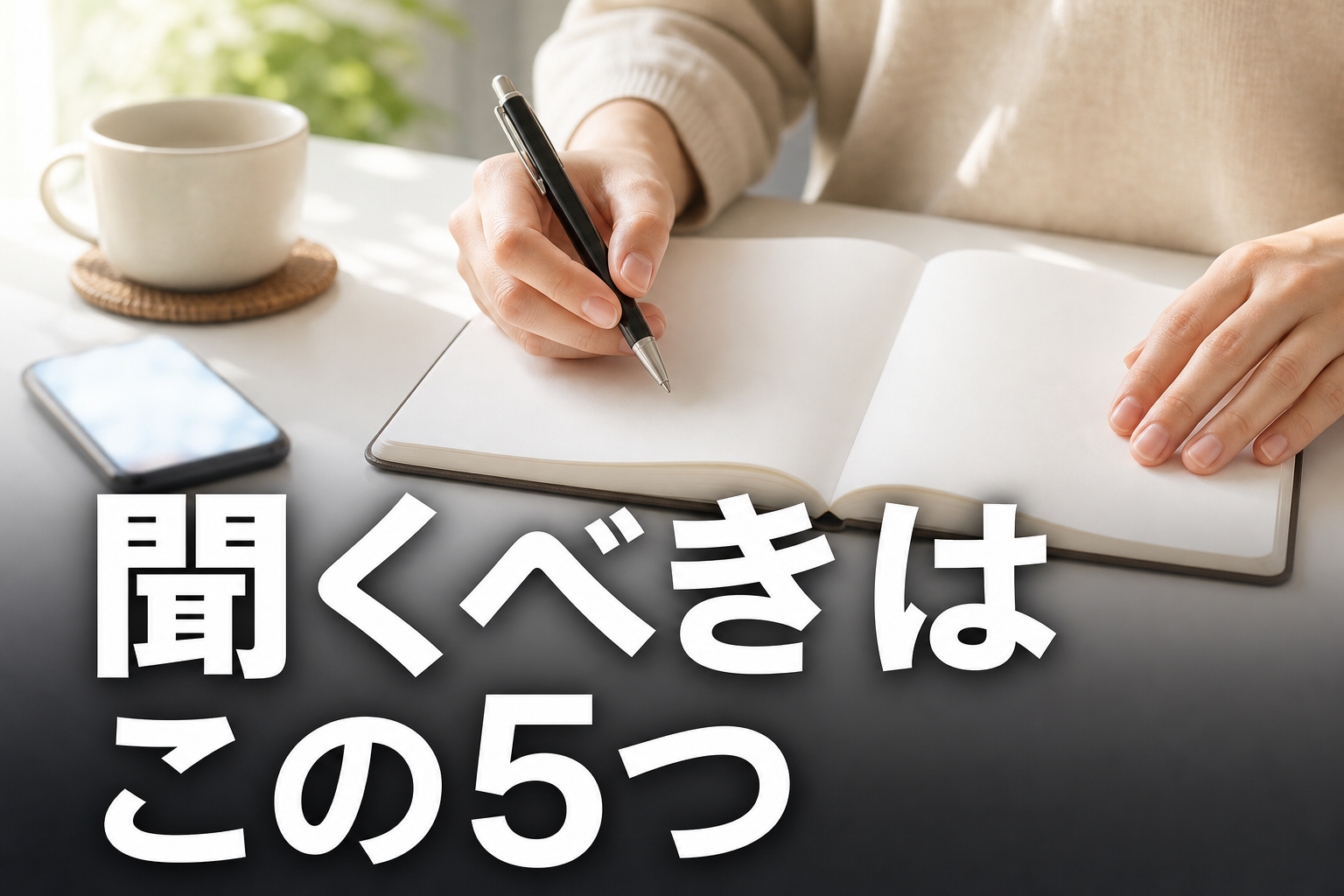 明るいテーブルでペンを持ち白紙のノートに向かう手元